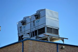 Rooftop EVAPCO cooling towers on brick building under clear blue sky