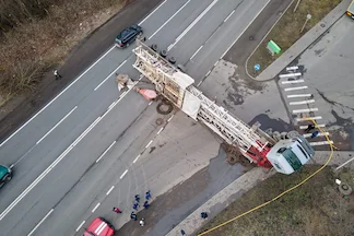 Aerial view of overturned commercial truck accident on highway with emergency responders