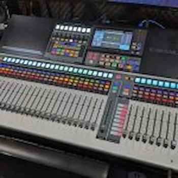 Professional digital audio mixing console with multicolored faders, touch screen display, and advanced control panels for music production.