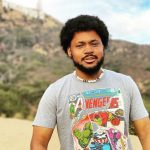 CoryxKenshin standing in desert landscape wearing Avengers t-shirt